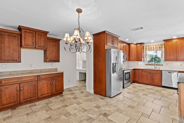 kitchen with a chandelier, pendant lighting, stainless steel appliances, and sink