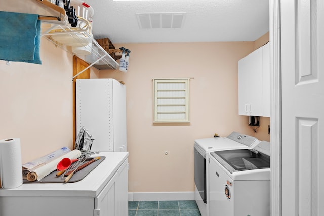 laundry room with washer and dryer, cabinets, light tile patterned floors, and a textured ceiling