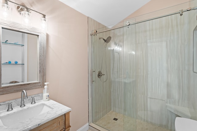 bathroom with vanity, a shower with shower door, lofted ceiling, and toilet