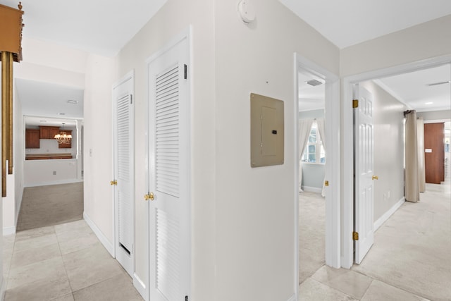 hallway featuring electric panel and light colored carpet