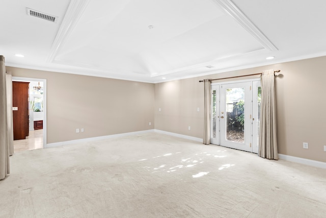 unfurnished living room with light colored carpet, ornamental molding, and a tray ceiling