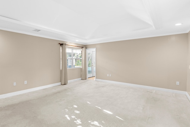 carpeted spare room featuring ornamental molding and a tray ceiling