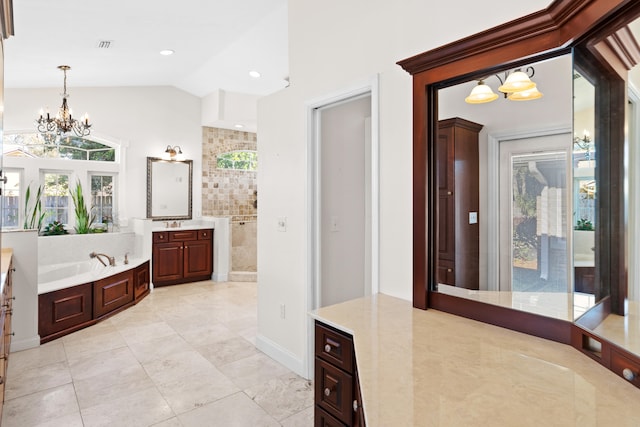 bathroom with a washtub, an inviting chandelier, tile patterned flooring, vaulted ceiling, and vanity