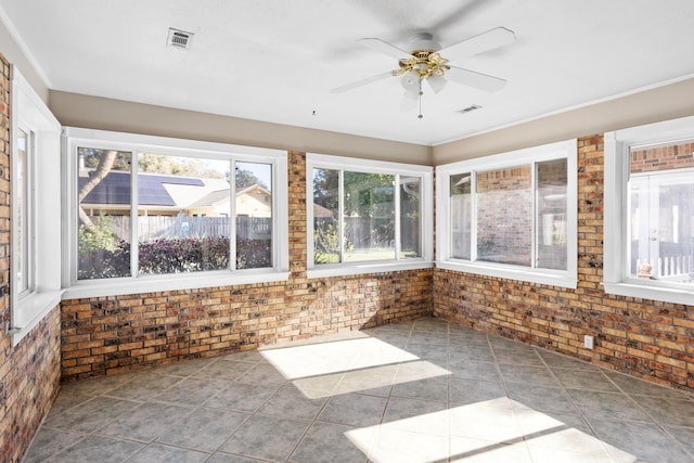 unfurnished sunroom featuring ceiling fan