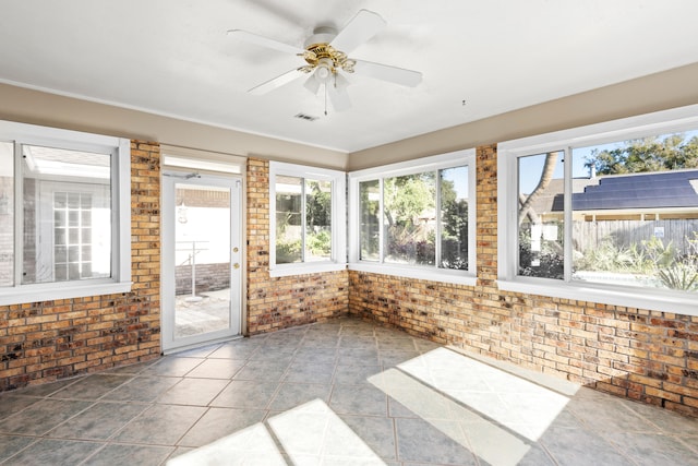 unfurnished sunroom featuring ceiling fan