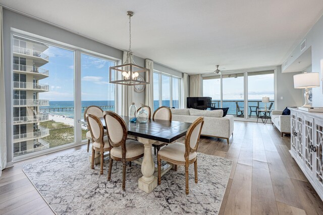 8477 Gulf Blvd Unit 1001, Navarre, FL 32566 - dining room featuring a healthy amount of sunlight, ceiling fan with notable chandelier, wood finished floors, and visible vents