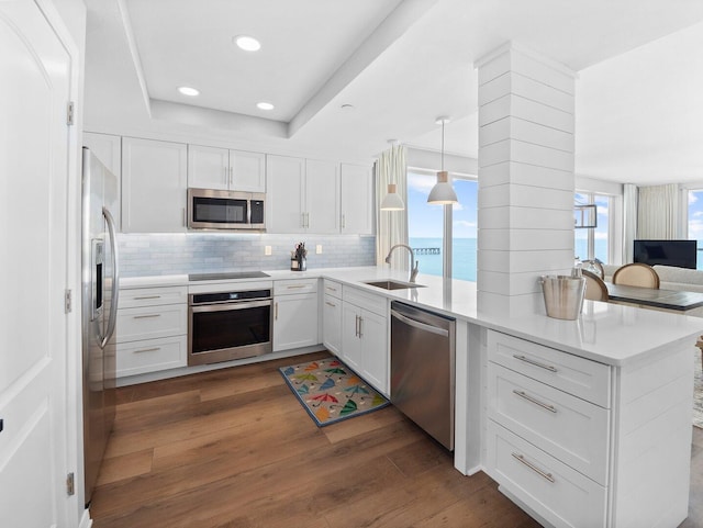 8477 Gulf Blvd Unit 1001, Navarre, FL 32566 - kitchen featuring a sink, white cabinetry, appliances with stainless steel finishes, and a peninsula