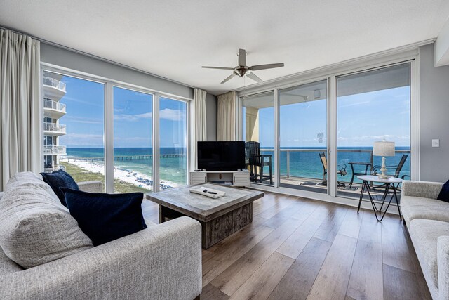 8477 Gulf Blvd Unit 1001, Navarre, FL 32566 - living area with a wall of windows, a ceiling fan, and hardwood / wood-style floors