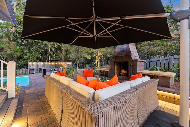 view of patio featuring a fenced in pool and an outdoor living space with a fireplace