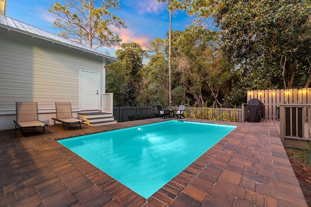 pool at dusk with a patio