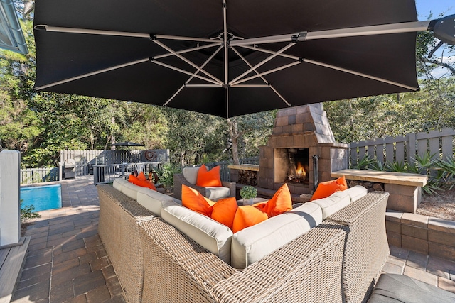 view of patio / terrace featuring an outdoor living space with a fireplace and a fenced in pool