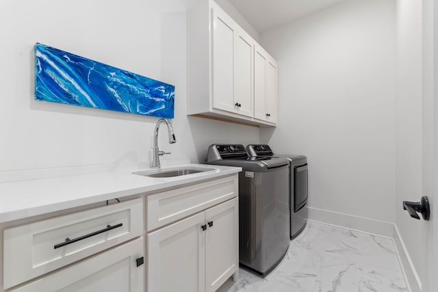 washroom featuring cabinets, sink, and washing machine and dryer