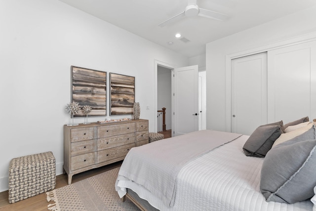 bedroom with wood-type flooring, a closet, and ceiling fan