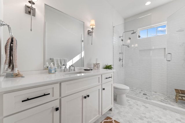 bathroom featuring a shower with shower door, vanity, and toilet