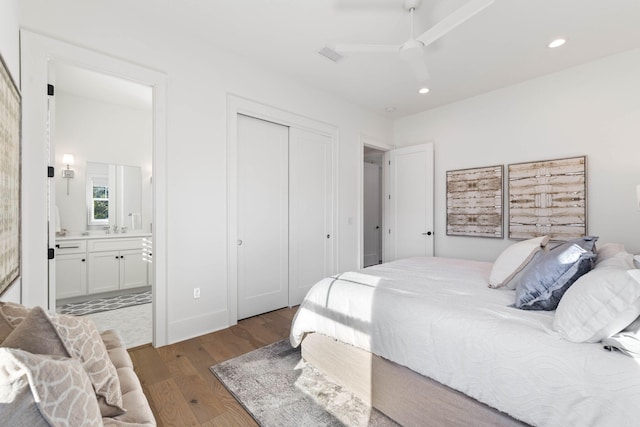 bedroom featuring a closet, light hardwood / wood-style floors, sink, ensuite bath, and ceiling fan