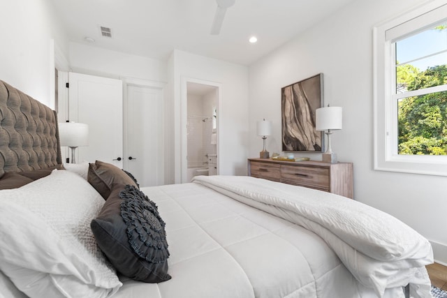 bedroom featuring hardwood / wood-style floors, ensuite bath, and ceiling fan