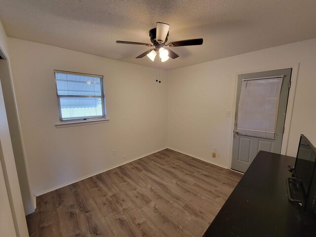 interior space with ceiling fan, dark wood-type flooring, and a textured ceiling