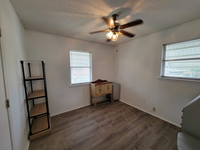 unfurnished bedroom with dark wood-type flooring, ceiling fan, and a textured ceiling