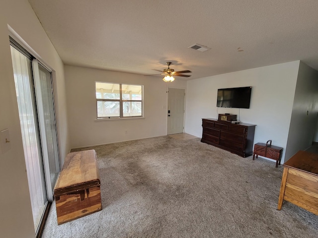 carpeted living room featuring a textured ceiling and ceiling fan