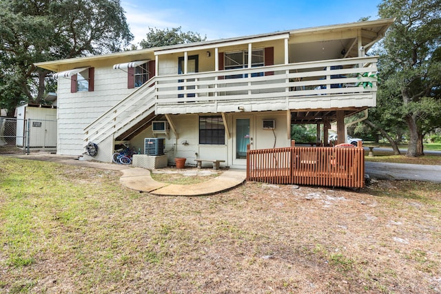 rear view of house featuring a wooden deck, a gate, stairway, central air condition unit, and fence
