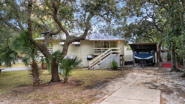 exterior space featuring stairway, driveway, and a carport