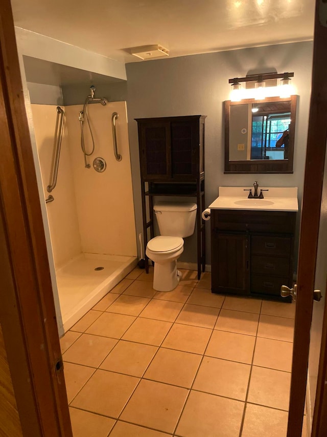 bathroom with tile patterned flooring, vanity, toilet, and walk in shower