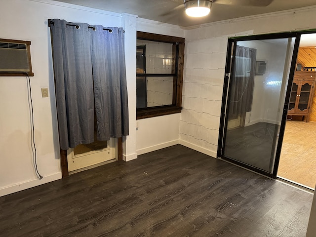 unfurnished room with dark wood-type flooring and an AC wall unit