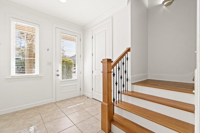 tiled foyer featuring crown molding