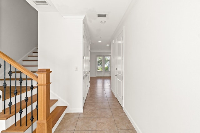 corridor featuring french doors, light tile patterned floors, and ornamental molding