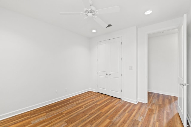 unfurnished bedroom featuring wood-type flooring, ceiling fan, and a closet