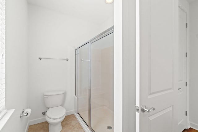 bathroom featuring toilet, tile patterned floors, and walk in shower