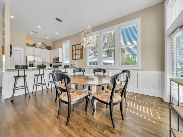 dining area with an inviting chandelier, dark hardwood / wood-style floors, and a healthy amount of sunlight