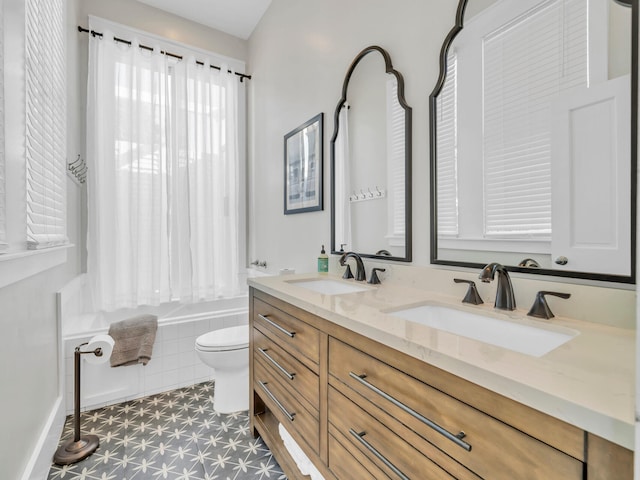 bathroom featuring toilet, vanity, and tiled tub