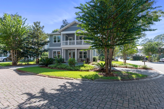 view of front facade with a front yard and a balcony