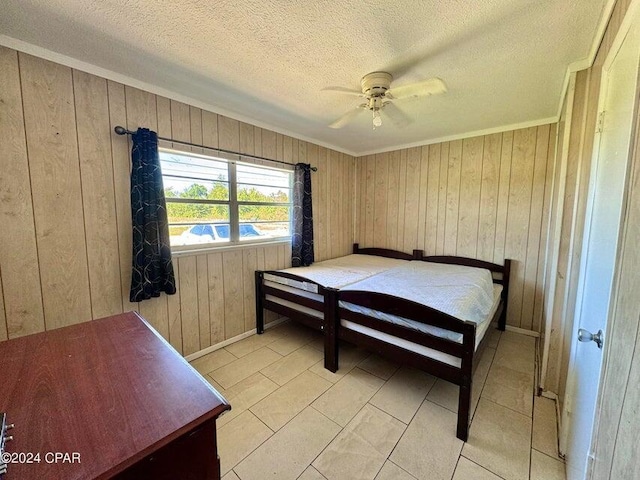 260 Seneca Ave, Panama City, FL 32404 - bedroom featuring ornamental molding, wooden walls, a textured ceiling, baseboards, and ceiling fan