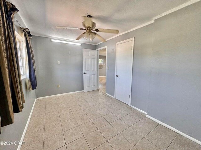 260 Seneca Ave, Panama City, FL 32404 - empty room featuring a ceiling fan, light tile patterned flooring, ornamental molding, and baseboards