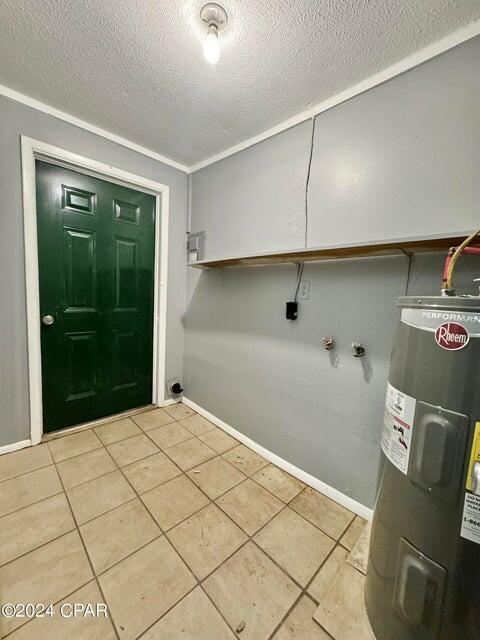 260 Seneca Ave, Panama City, FL 32404 - washroom with electric water heater, light tile patterned flooring, a textured ceiling, and baseboards