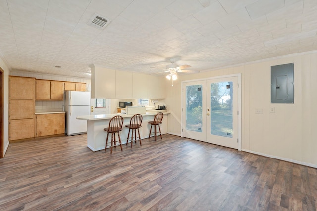 kitchen with white refrigerator, electric panel, ceiling fan, hardwood / wood-style floors, and kitchen peninsula