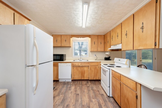 kitchen featuring sink, kitchen peninsula, white appliances, tasteful backsplash, and hardwood / wood-style floors