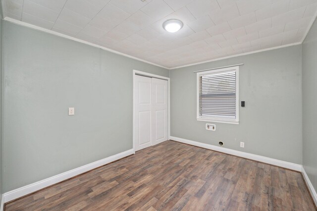 empty room with dark hardwood / wood-style floors and ornamental molding