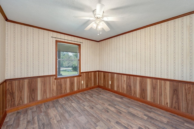 empty room featuring wood-type flooring, ceiling fan, crown molding, and a textured ceiling