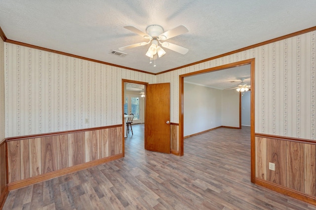 spare room with hardwood / wood-style flooring, ceiling fan, and a textured ceiling