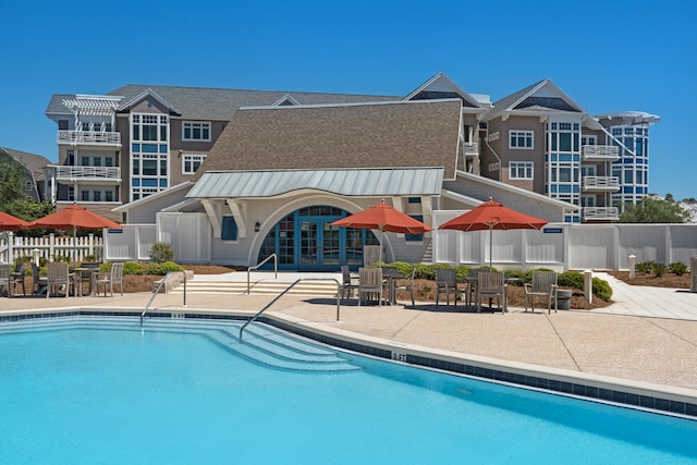 view of swimming pool with a patio and french doors