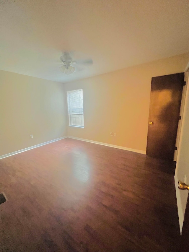 unfurnished room with ceiling fan and dark colored carpet