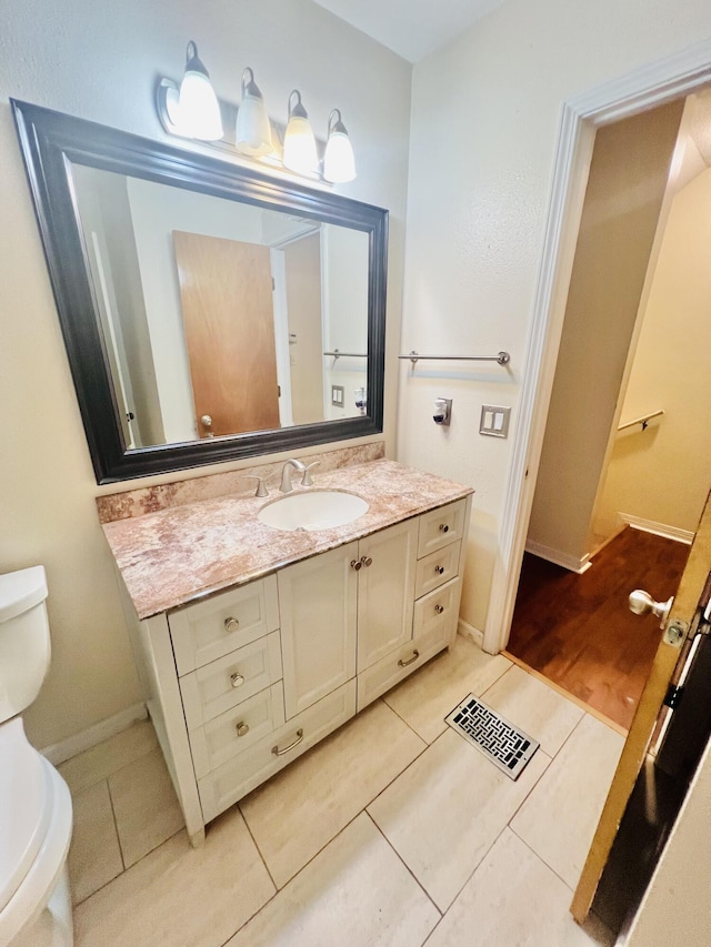 bathroom with toilet, visible vents, tile patterned flooring, and vanity