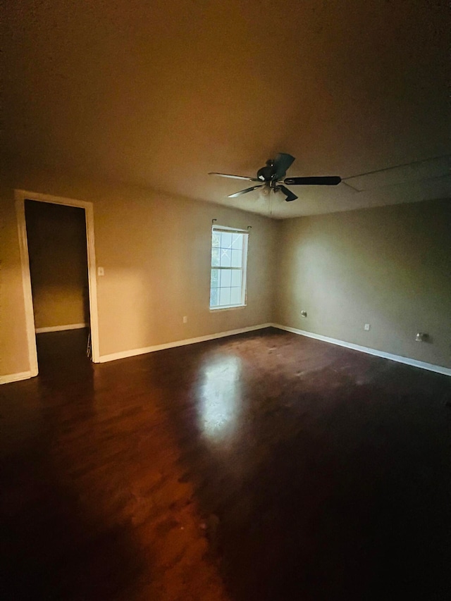 spare room featuring dark wood-type flooring and ceiling fan