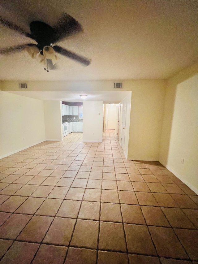 spare room with a ceiling fan, baseboards, visible vents, and light tile patterned floors