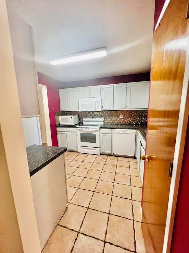 kitchen with white cabinetry, light tile patterned flooring, white appliances, and tasteful backsplash