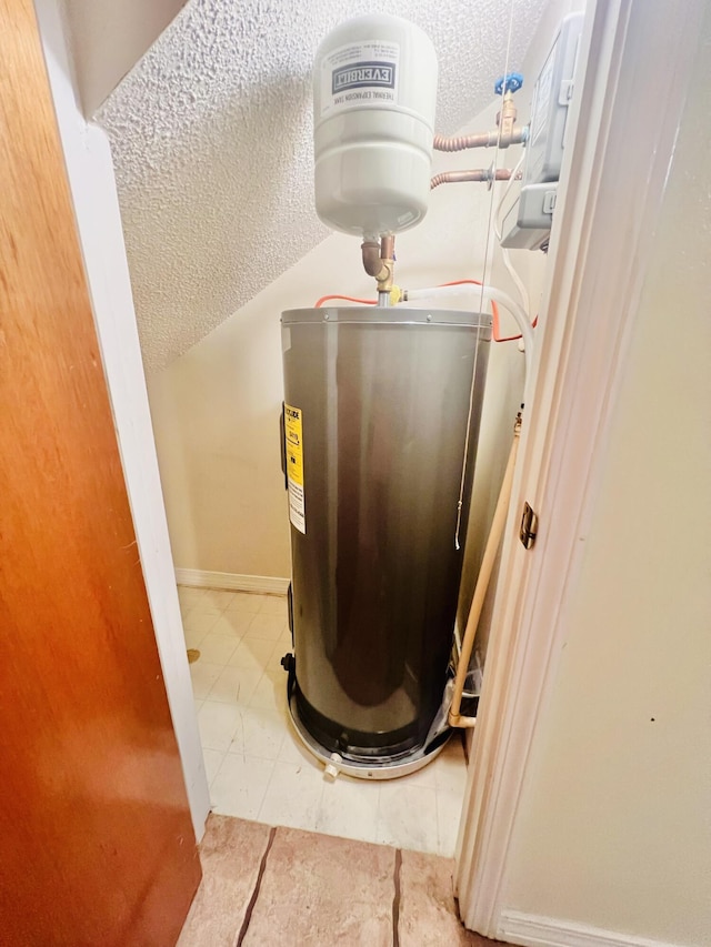 details with baseboards, a textured ceiling, and electric water heater