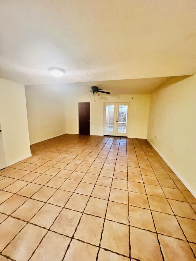 unfurnished room with light tile patterned floors, a ceiling fan, and french doors